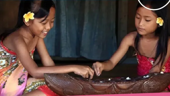 dua anak perempuan bermain congklak